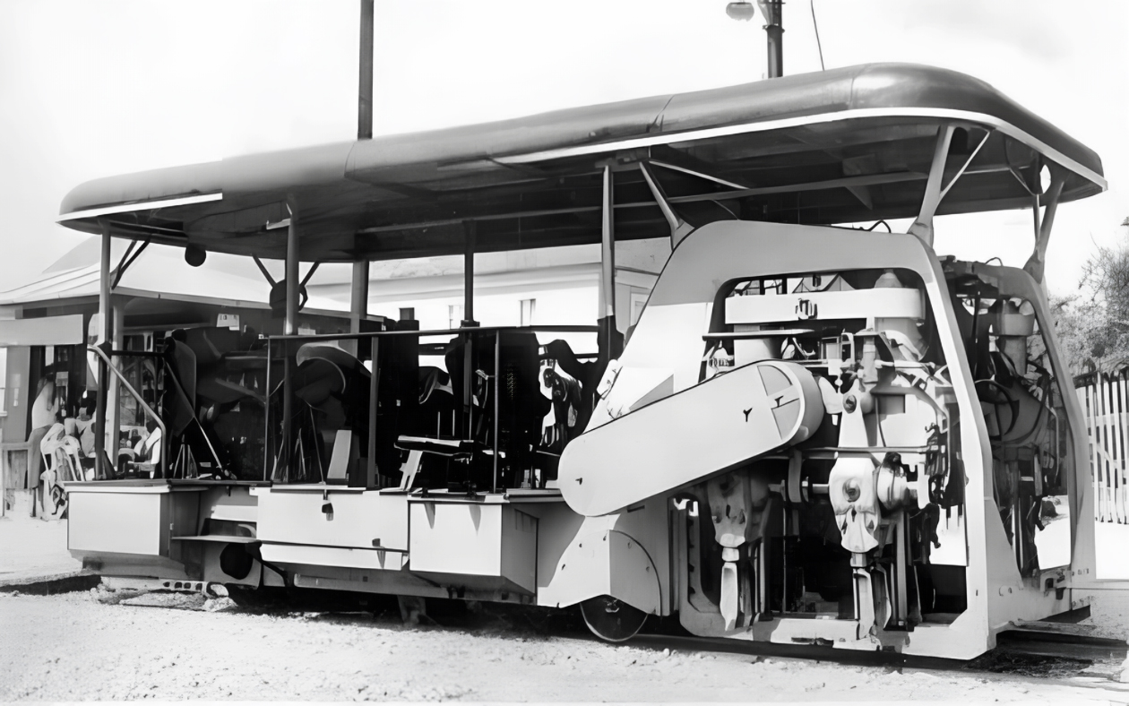 Schwarz-Weiß-Foto einer Stopfmaschine für den Gleisbau mit überdachtem Bedienstand und sichtbaren mechanischen Details