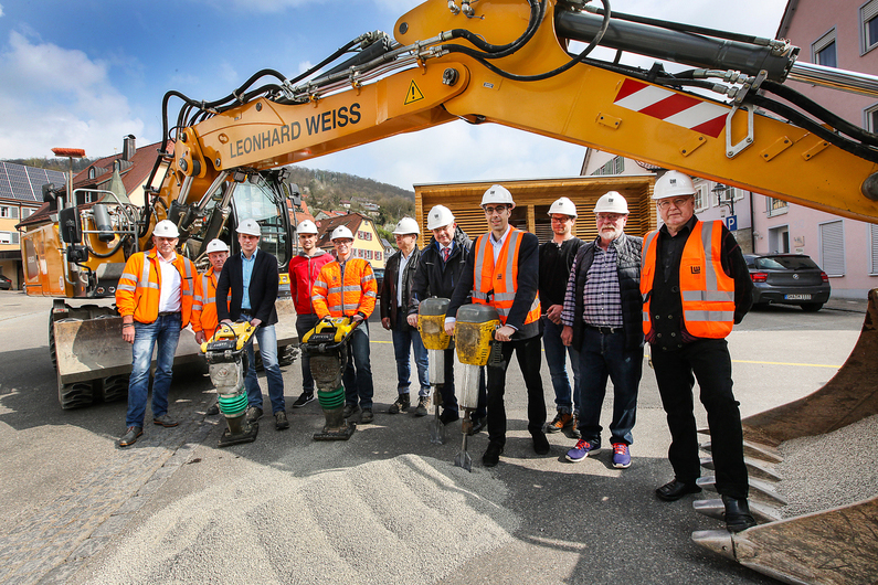 Gruppenfoto in Braunsbach mit elf Männern vor einem Bagger