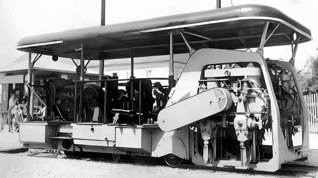 Schwarz-Weiß-Foto einer Stopfmaschine für den Gleisbau mit überdachtem Bedienstand und sichtbaren mechanischen Details