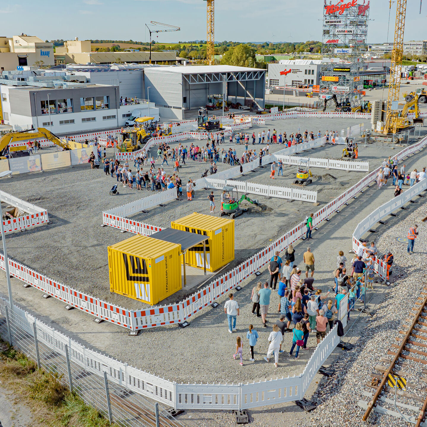 The LEONHARD WEISS training centre with practice area, railway tracks, construction machinery and visitors at an event