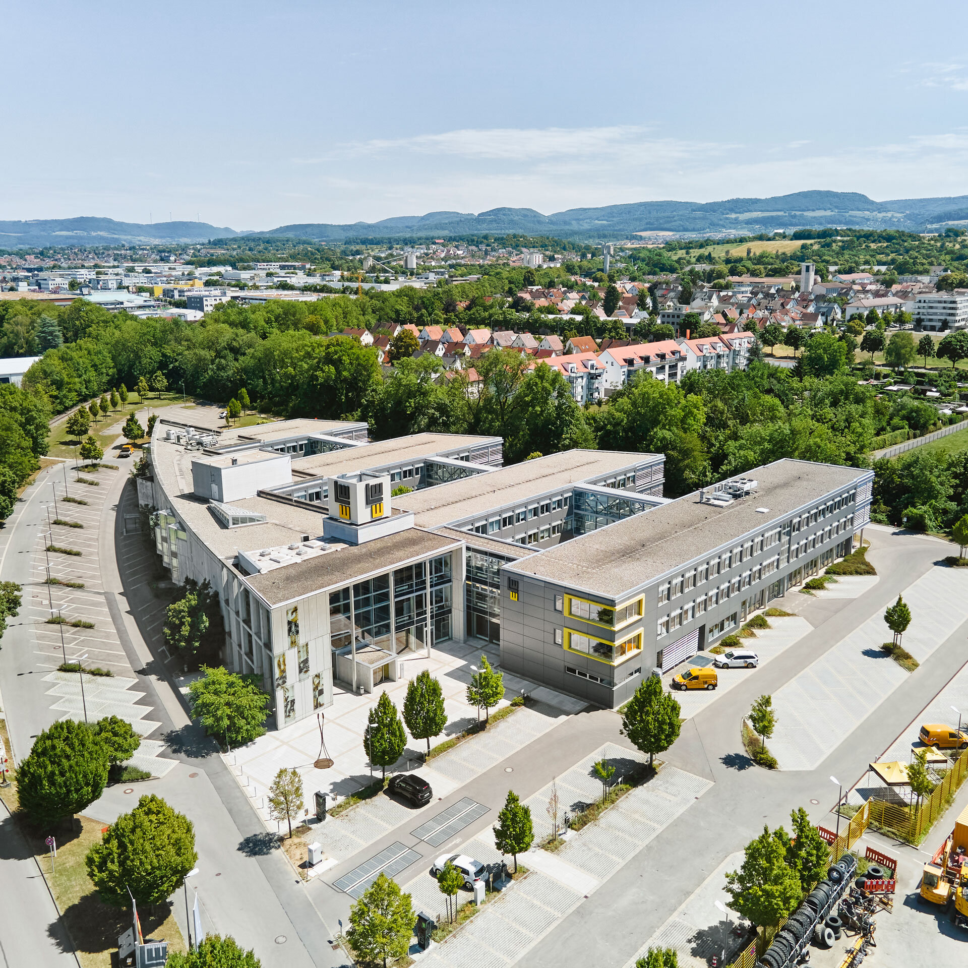 Aerial view of the LEONHARD WEISS site in Göppingen with extensive grounds, modern buildings, car parks and surrounding green landscape