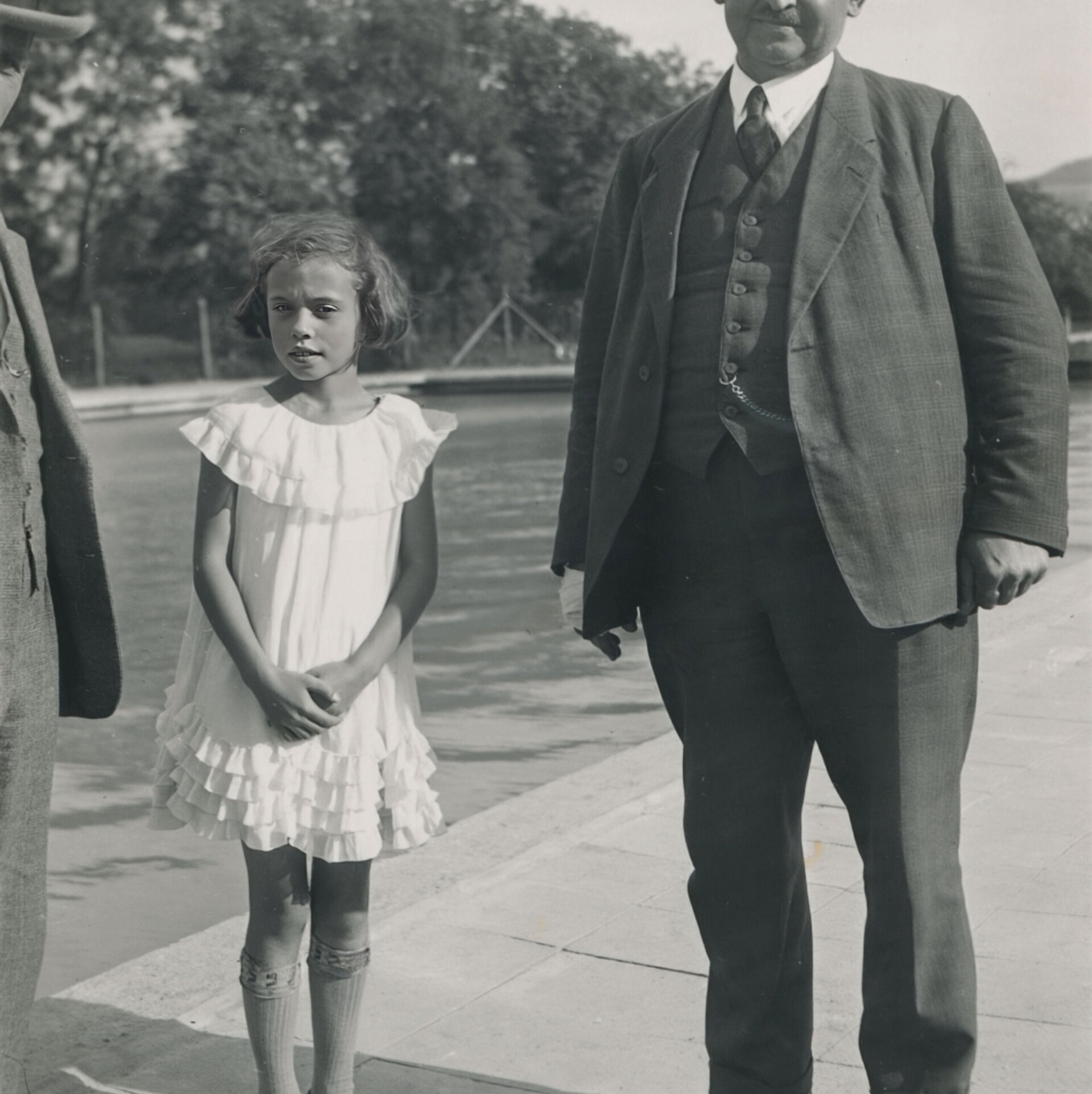 Leonhard Weiß standing next to a young girl, taken on a sunny day in front of a body of water