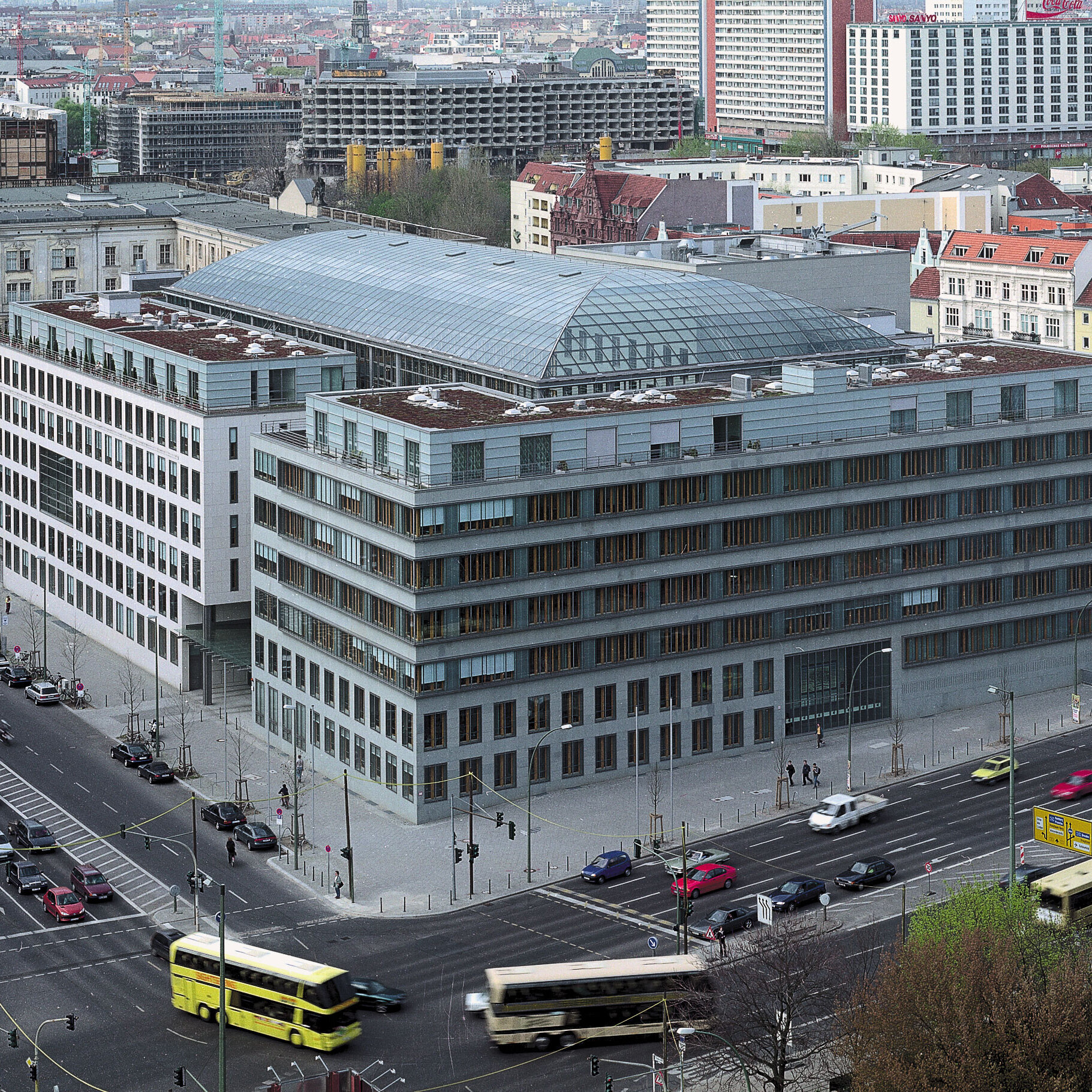 Building of the German Chamber of Industry and Commerce (DIHK) in Berlin, modern architecture with glass roof, surrounded by city traffic and other urban buildings