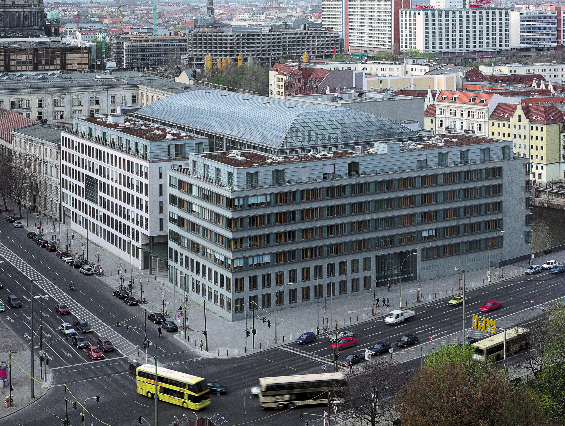 Gebäude der Deutschen Industrie- und Handelskammer (DIHK) in Berlin, moderne Architektur mit Glasdach, umgeben von Stadtverkehr und weiteren städtischen Gebäuden