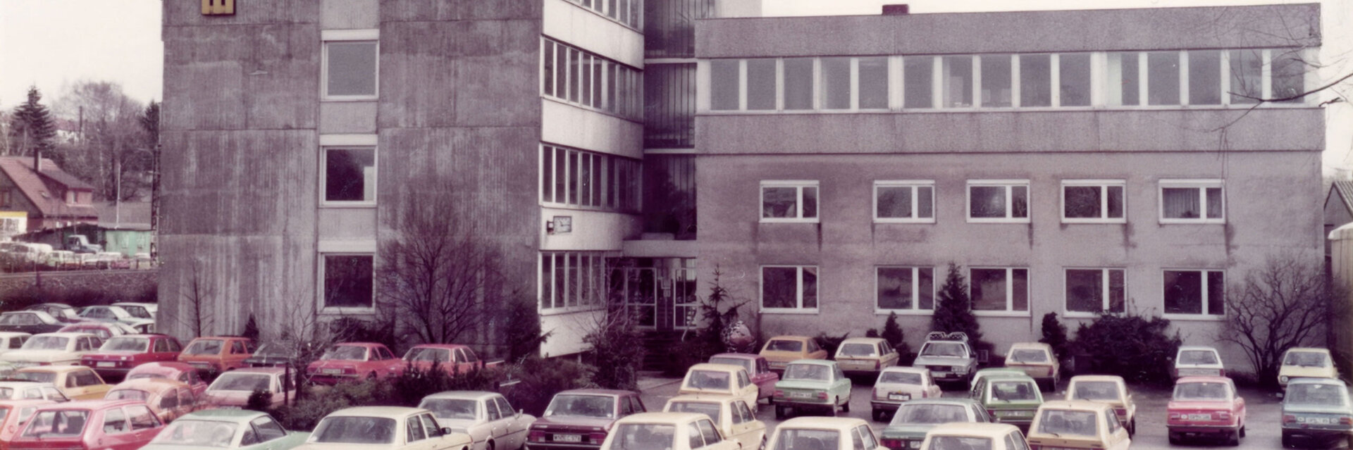 Farbfoto des Firmengebäudes von LEONHARD WEISS in Göppingen mit geparkten Autos auf dem Vorplatz