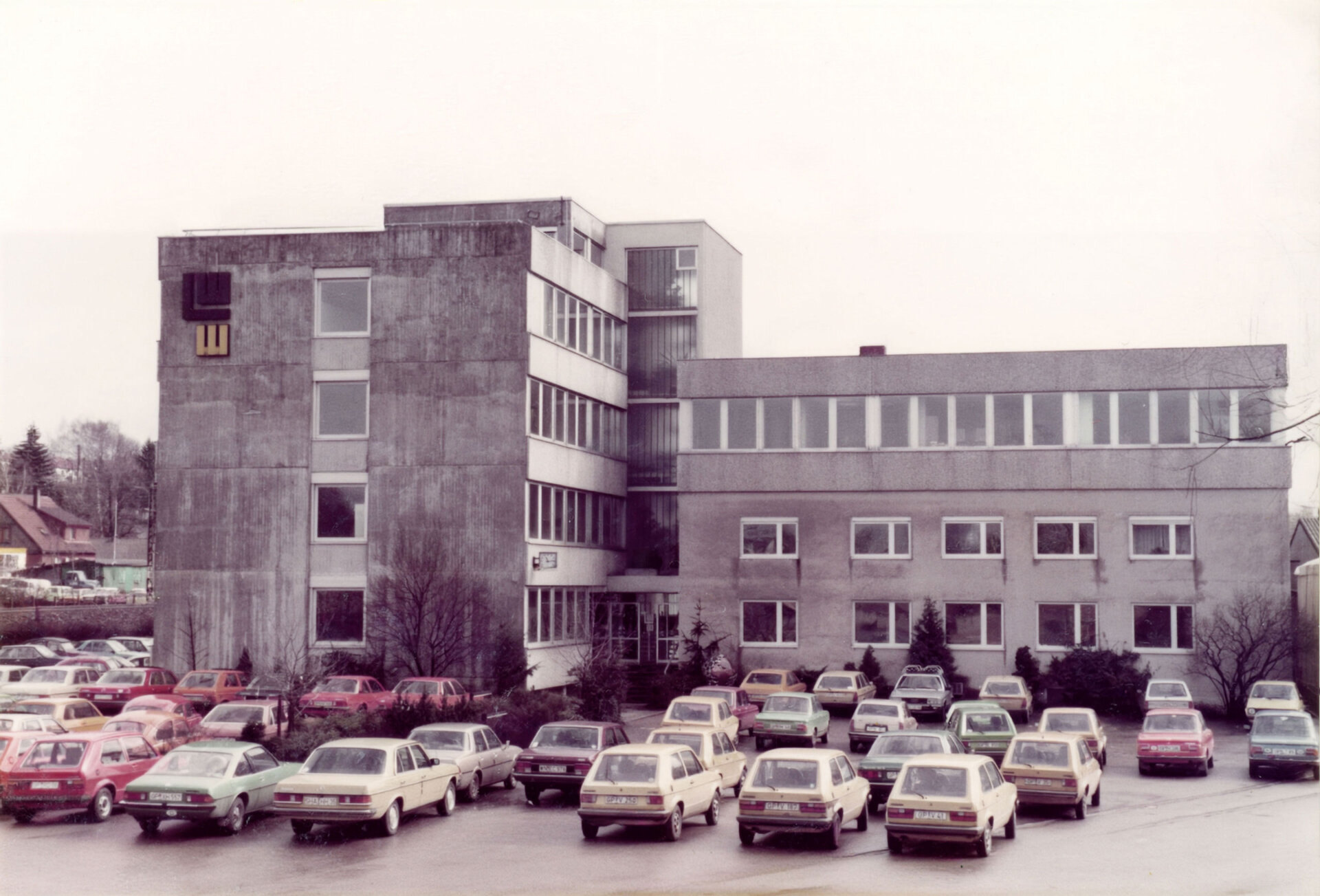 Farbfoto des Firmengebäudes von LEONHARD WEISS in Göppingen mit geparkten Autos auf dem Vorplatz