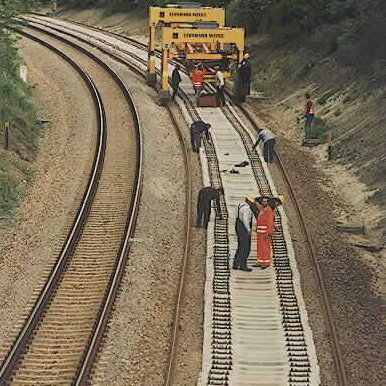 Track construction work on the Plauen-Syrau line with a track-laying vehicle and several workers on the tracks