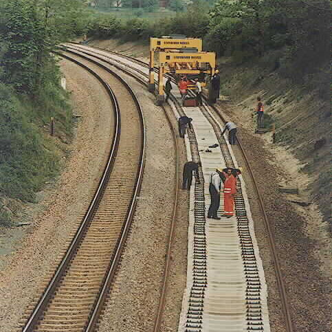 Gleisbauarbeiten der Strecke Plauen-Syrau mit einem Schienenverlegefahrzeug und mehreren Arbeitern auf den Gleisen